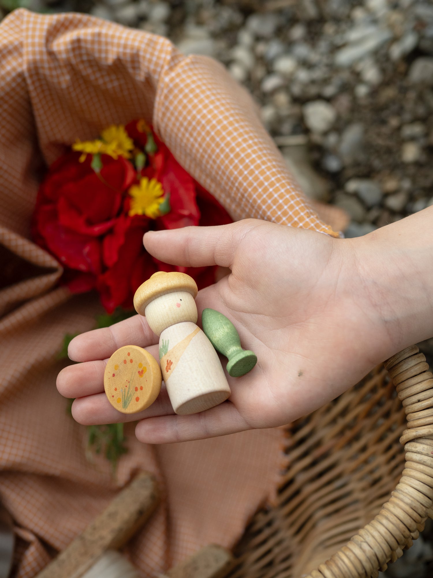 Hand holding a small wooden toy with a blurred background