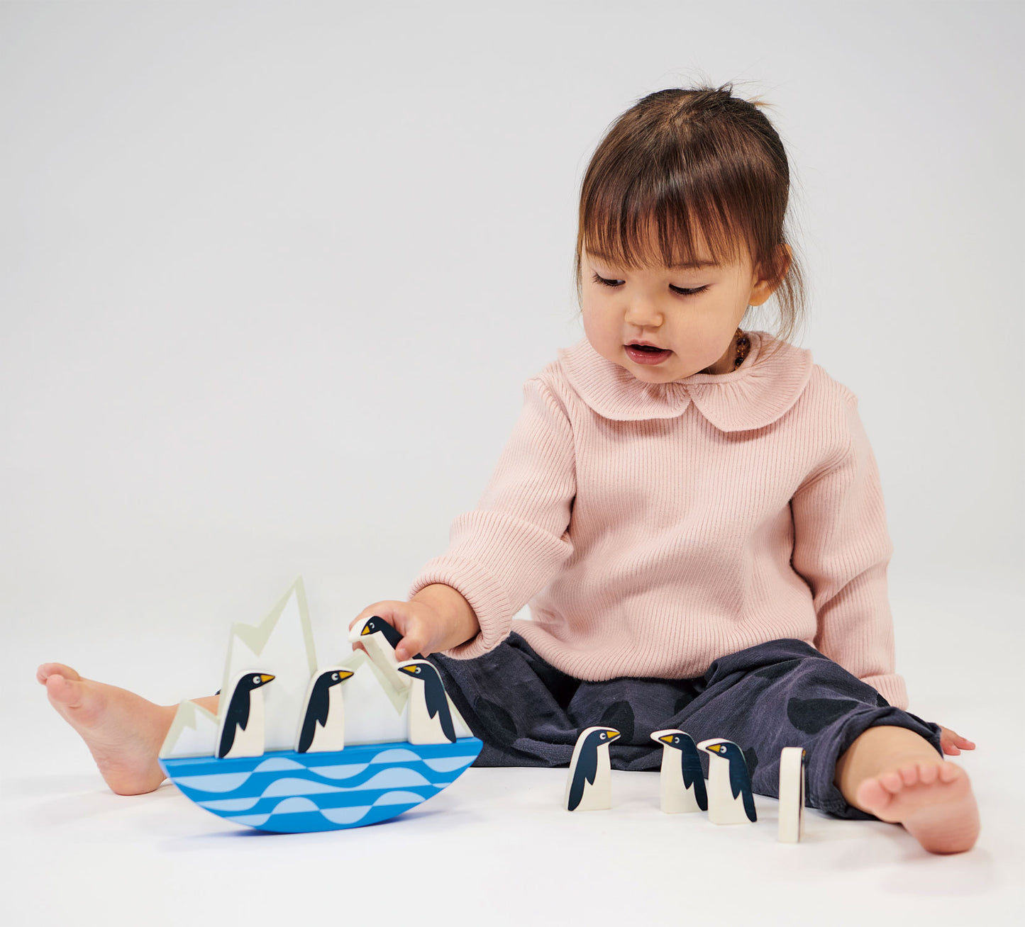 Child playing with balancing penguins game.