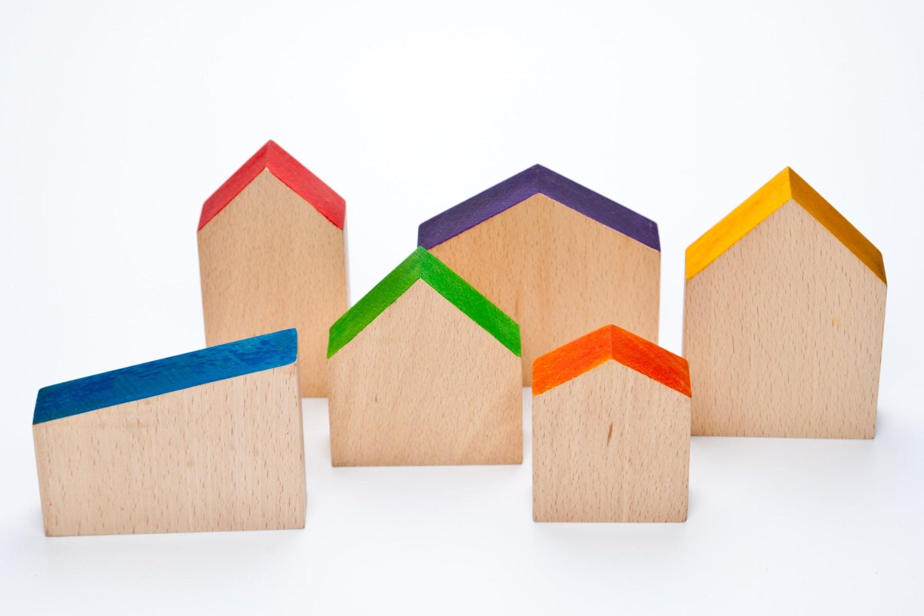  A set of wooden toy houses in various shapes with brightly coloured roofs