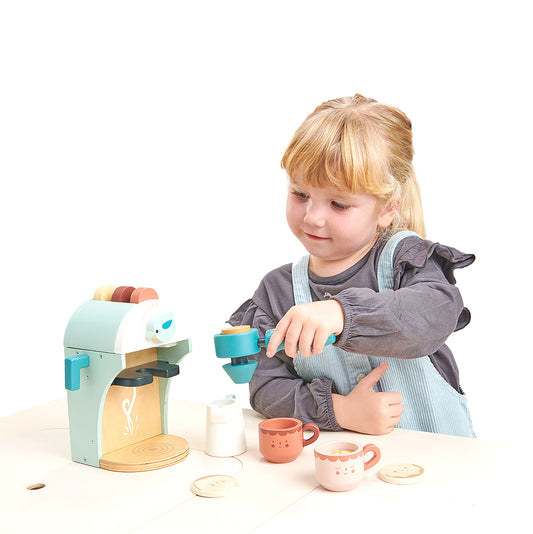 Child playing with wooden toy cappuccino maker.
