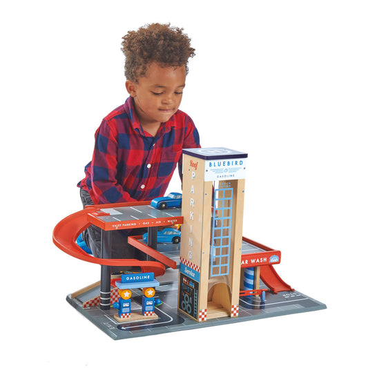Child playing with wooden garage set