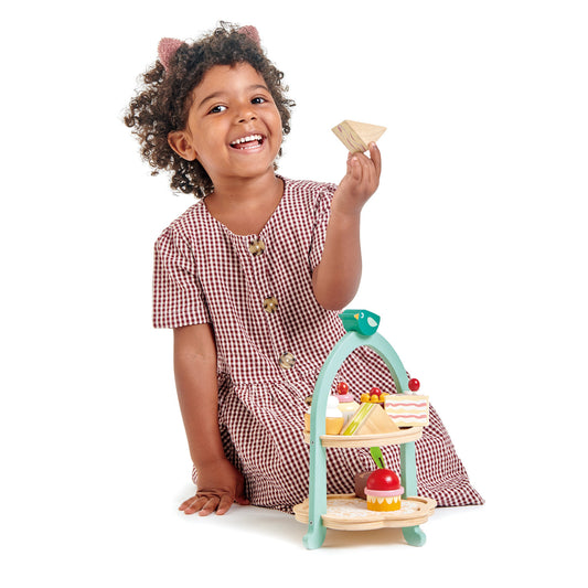 Child playing with wooden toy afternoon tea set