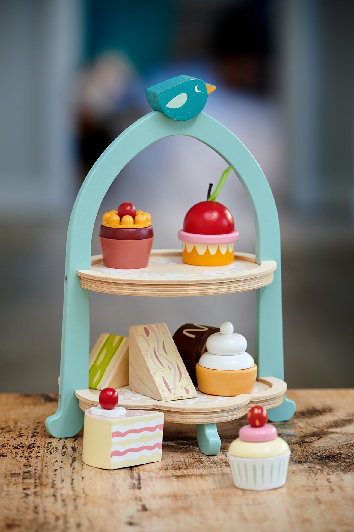 Wooden afternoon tea set with stand, sandwiches and an assortment of cakes 